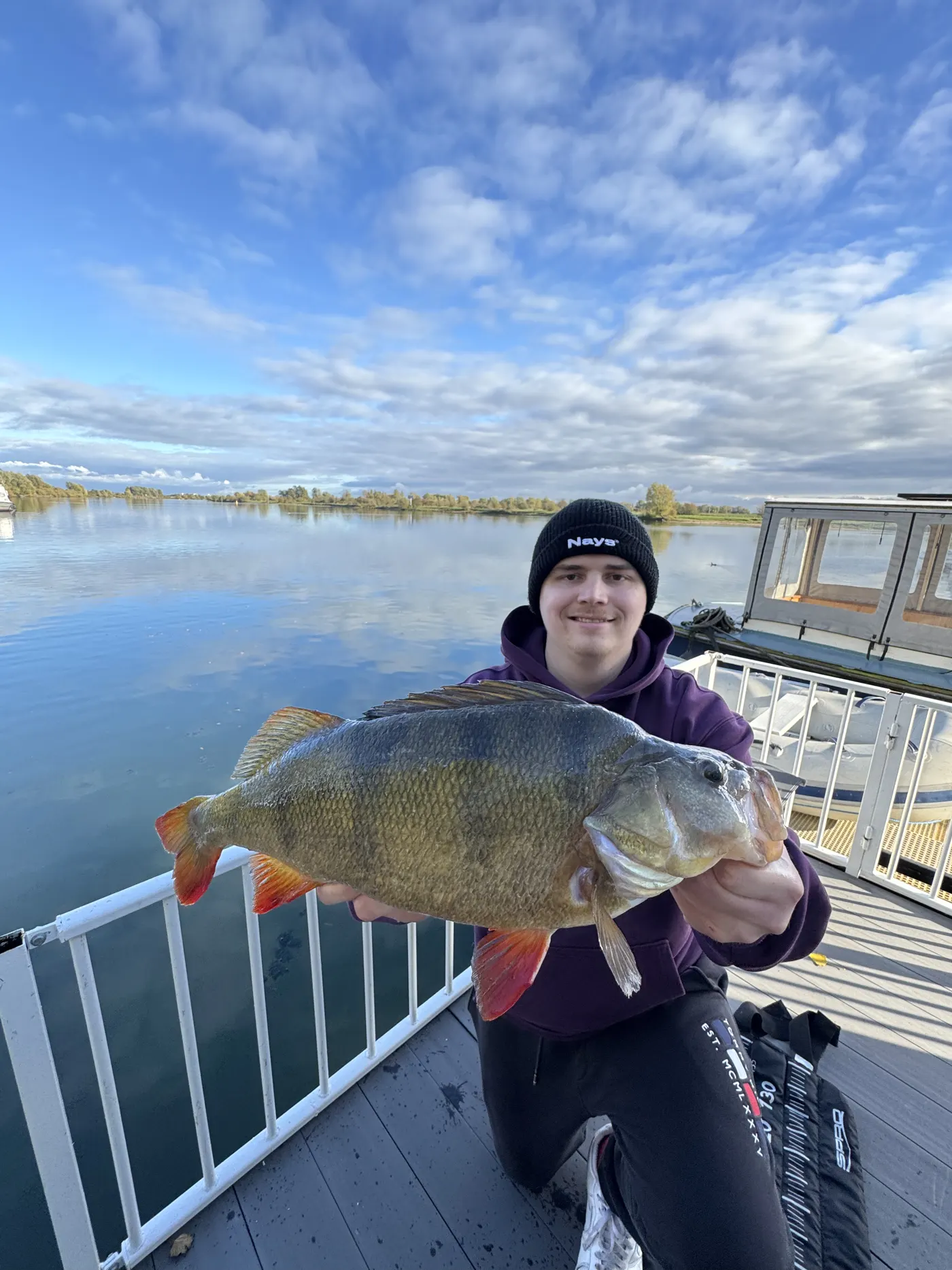 Angler mit Barsch auf dem Hausboot